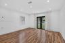 Interior space featuring wood-finish flooring, recessed lighting, and black-framed double glass doors providing an exterior perspective