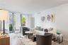 Floor-to-ceiling glass sliding doors, wood-finish flooring, and balcony access