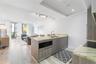 Kitchen featuring an island with a double-basin sink, stone countertops, built-in drawer microwave, and wood-finish cabinetry, complemented by wood-fi
