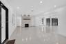 Open-concept interior featuring large-format polished tile flooring, stone-veneer fireplace with a wood mantel, recessed ceiling lighting, and floor-t