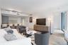 Open concept interior featuring wood-finish flooring, recessed track lighting, and a kitchen peninsula with integrated stone-finish countertop