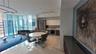 Open-concept interior featuring floor-to-ceiling windows, polished stone flooring, custom kitchen cabinetry with integrated appliances, and recessed t