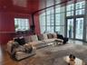 Curved, high-gloss red wall featuring an integrated service counter, floor-to-ceiling windows, recessed ceiling lighting, and double-door balcony acce