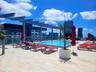 Rooftop terrace featuring an elevated swimming pool, metal pergola, tile flooring, and glass panel railing