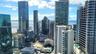 High-rise urban panorama featuring glass-facade skyscrapers, bay water, and distant bridge infrastructure