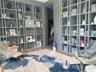 Floor-to-ceiling built-in shelving featuring a monochromatic finish and wood-finish flooring