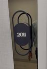 Modern metallic door plaque featuring a matte black geometric frame and integrated Braille signage