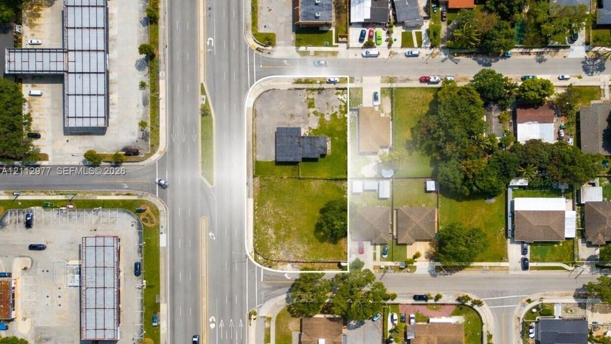 Corner lot featuring street frontage, cleared land, and mature perimeter trees
