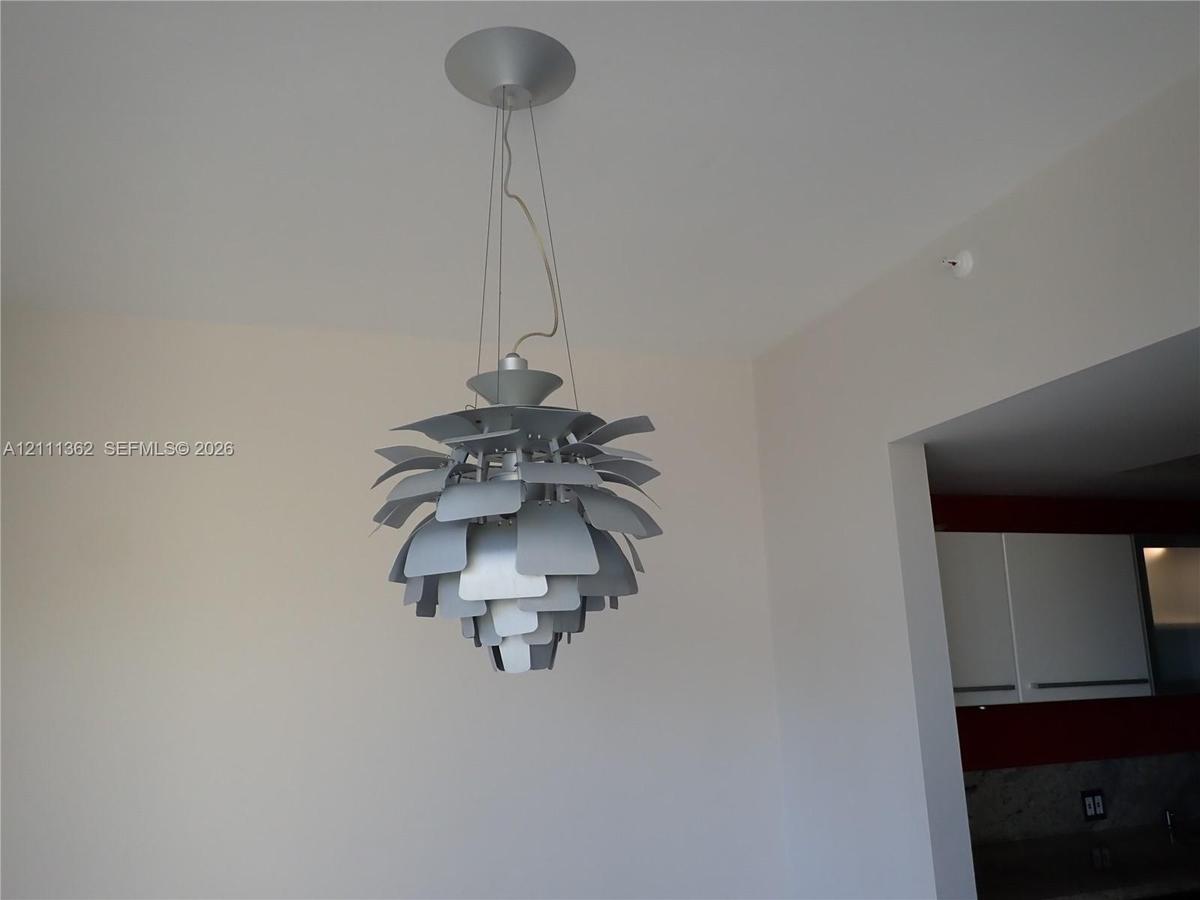 Sculptural metallic pendant light fixture with tiered, layered leaves and a circular ceiling mount