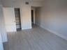 Interior space featuring wood-finish flooring, neutral wall paint, and a built-in closet with multi-tier shelving
