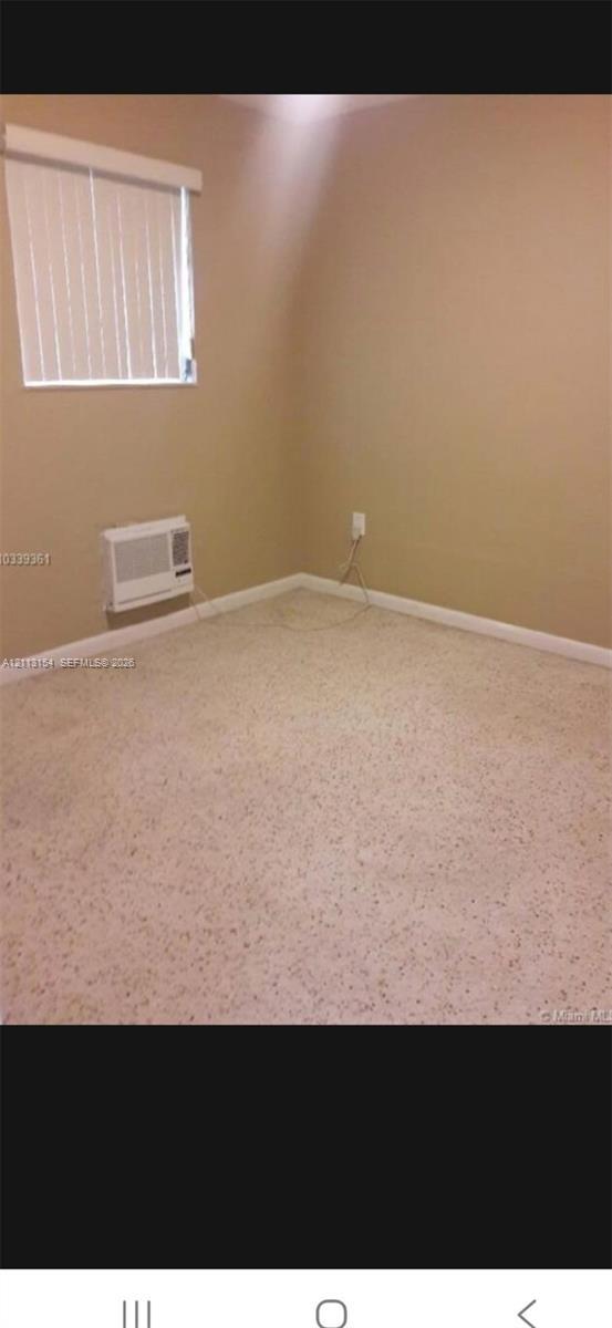 Wall-to-wall carpeting, neutral wall color, and window with white horizontal blinds