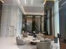 Grand lobby featuring floor-to-ceiling stone wall cladding, polished flooring, integrated linear recessed lighting, a multi-story water feature, and d