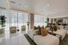 Open-concept interior featuring polished stone flooring, expansive floor-to-ceiling windows with integrated drapery tracks, recessed cove lighting, an