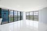 Floor-to-ceiling glass walls, polished white tile flooring, expansive corner layout, and structural balcony railing