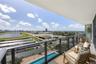 Covered terrace featuring a glass panel railing, expansive exterior area, and direct exposure to race track and urban scenery