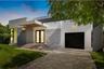 Modern exterior featuring a smooth stucco facade, dual-tone architectural detailing, a covered entrance with wood-paneled ceiling, and a concrete driv