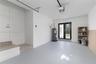 Garage interior featuring painted concrete flooring, a tiled step entry, and a double-glass door