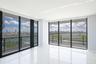 Floor-to-ceiling glass walls, expansive private balcony with metal railing, high-gloss tile flooring, and open-plan interior