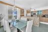 Kitchen featuring light-finish cabinetry, stone-tiled backsplash, and a stone-clad breakfast bar