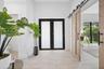 Entryway featuring double doors with frosted glass insets, large-format tile flooring, and wood-finish sliding barn doors with black metal hardware