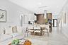 Open-concept kitchen featuring chevron-patterned backsplash tile, center island with stone countertop, stainless steel range hood, built-in wall oven,