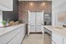 Modern kitchen featuring full-height geometric patterned cabinetry, integrated side-by-side refrigerator, built-in stainless steel oven and microwave,