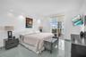 Recessed ceiling lighting, large-format tile flooring, and sliding glass door access to a private balcony