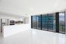Open-concept kitchen featuring high-gloss cabinetry, stainless steel appliances, and a breakfast bar, highlighted by large-format flooring and floor-t