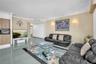 Large format tile flooring, crown molding, and wall-mounted decorative light fixtures