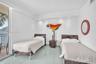 Neutral-toned interior featuring large-format tile flooring, recessed ceiling lighting, and a sliding glass door providing access to a private balcony