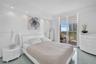 Sleek tile flooring, recessed ceiling lighting, and sliding glass doors opening to a private balcony with an exterior railing