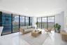 Floor-to-ceiling windows featuring panoramic city and track scenery, complemented by polished tile flooring and recessed ceiling lighting