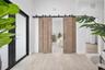 Double sliding barn doors with a matte black metal track system, wood-finish flooring, and black-framed glass entry door
