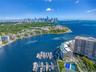 Aerial perspective of waterfront property featuring a private boat dock, marina slip access, tennis courts, and landscaped grounds