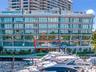 Multi-story contemporary exterior featuring floor-to-ceiling glass paneling, horizontal cantilevered balconies with glass railings, and a deep-water m