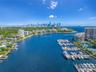 Aerial perspective of deep-water frontage featuring a multi-slip private marina, boat docking infrastructure, and direct water access
