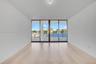 Floor-to-ceiling glass doors, neutral wood-finish flooring, recessed lighting, and outdoor terrace access