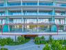 Expansive private terrace featuring glass panel railings, floor-to-ceiling sliding glass walls, and unobstructed water frontage