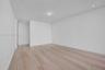Neutral-toned interior space featuring wood-finish flooring, crisp white walls, and recessed ceiling lighting