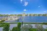 Waterfront property featuring a concrete seawall, paver-stone walking path, integrated landscaping, and direct deep-water frontage