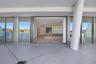 Covered terrace featuring stone tile flooring and a structural cylindrical column, spanning wide sliding glass doors that reveal wood-finish flooring 