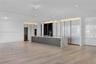 Modern kitchen featuring high-gloss cabinetry, a central island with stone surfacing, integrated appliances, recessed lighting, and wood-finish floori