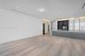 Minimalist interior featuring large-format stone-finish flooring, recessed linear lighting, and integrated ceiling spotlights