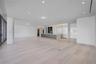 Open-concept space featuring light-toned wood-finish flooring, recessed ceiling lighting, floor-to-ceiling glass sliding doors, and a kitchen island w