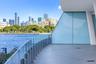 Curved terrace featuring a glass panel railing, tile flooring, and floor-to-ceiling glass wall
