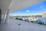 Covered terrace featuring large-format tile flooring, angled structural columns, and a direct water frontage with marina access