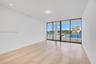 Floor-to-ceiling glass sliding doors, wood-finish flooring, recessed lighting, and water frontage