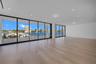 Expansive interior featuring floor-to-ceiling glass sliding doors, wood-finish flooring, recessed lighting, and a covered exterior deck