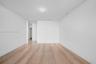 Interior space featuring light wood-finish flooring, smooth white walls, recessed ceiling lighting, and a linear slot ceiling diffuser