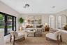 Neutral-toned interior featuring wood-finish flooring, dual black-framed glass panel doors, and an arched entryway